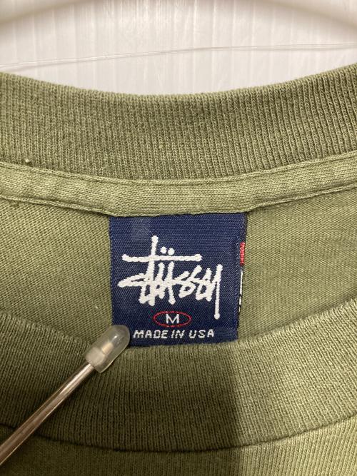 stussy（ステューシー）stussy (ステューシー) プリントTシャツ / 紺タグ オリーブ サイズ:Mの古着・服飾アイテム