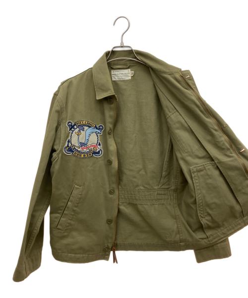 TOYS MCCOY（トイズマッコイ）TOYS McCOY (トイズマッコイ) TM&WarnerBros (ワーナー・ブラザース) ミリタリージャケット ロードランナー カーキ サイズ:Sの古着・服飾アイテム
