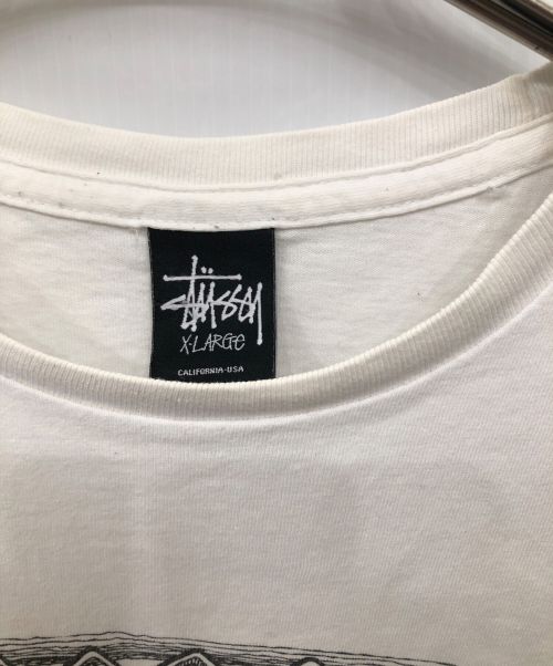 stussy（ステューシー）stussy (ステューシー) サーフマン＆ビッグプリントTシャツ／SURFMAN & BIG PRINT T ホワイト サイズ:SIZE XLの古着・服飾アイテム