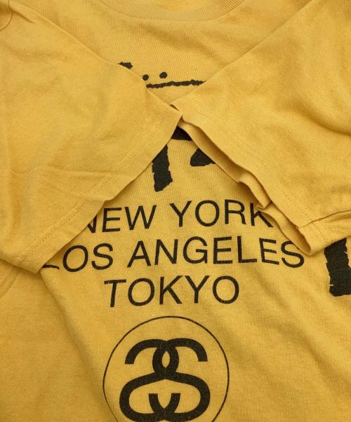 stussy（ステューシー）stussy (ステューシー) WORLD TOUR（ワールドツアー）Tシャツ イエロー サイズ:Mの古着・服飾アイテム