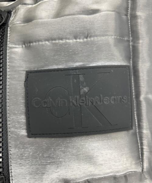 Calvin Klein Jeans（カルバンクラインジーンズ）Calvin Klein Jeans (カルバンクラインジーンズ) リキッドメタルパファージャケット グレー サイズ:SIZE Mの古着・服飾アイテム