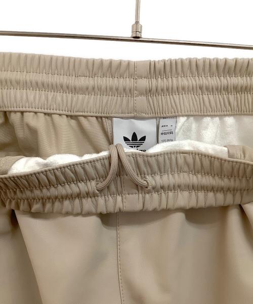 adidas（アディダス）adidas (アディダス) フェイクレザーアディカラー スリーストライプス ファイヤーバードトラックスーツパンツ ベージュ サイズ:Mの古着・服飾アイテム