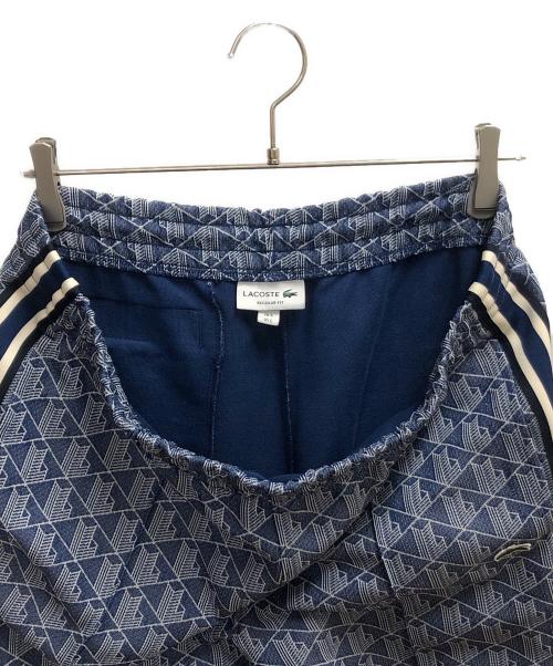 LACOSTE（ラコステ）LACOSTE (ラコステ) サイドテーピングモノグラムジャカードトラックパンツ ブルー×ホワイト サイズ:SIZE L(US)の古着・服飾アイテム