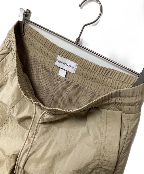 Calvin Klein Jeans（カルバンクラインジーンズ）Calvin Klein Jeans (カルバンクラインジーンズ) ナイロンパンツ ベージュ サイズ:Sの古着・服飾アイテム