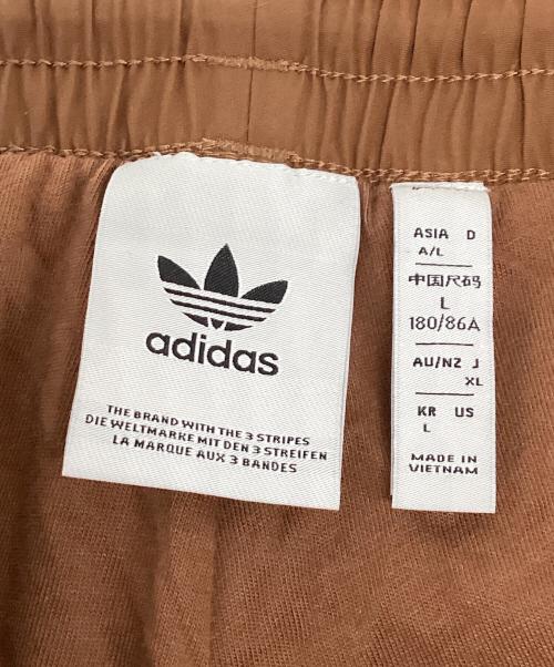 adidas（アディダス）adidas (アディダス) アディカラー ウーブン ファイヤーバードトラックパンツ ブラウン サイズ:Lの古着・服飾アイテム