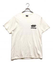 stussy（ステューシー）の古着「サーフマン プリントTシャツ」｜ホワイト