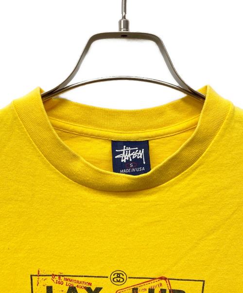stussy（ステューシー）stussy (ステューシー) 国際空港コード プリントTシャツ イエロー サイズ:Sの古着・服飾アイテム