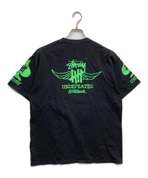 stussy（ステューシー）stussy (ステューシー) UNDEFEATED (アンディフィーテッド) コラボプリントTシャツ ブラック サイズ:Lの古着・服飾アイテム