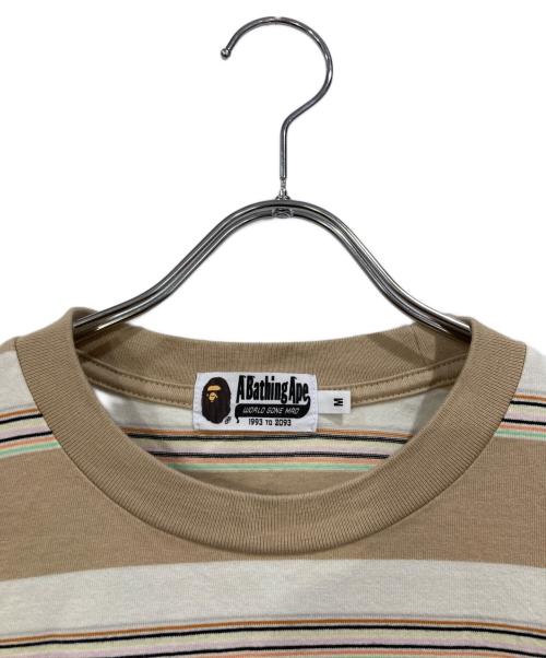 A BATHING APE（アベイシングエイプ）A BATHING APE (アベイシングエイプ) STRIPE ONE POINT RELAXED FIT POCKET LS TEE ベージュ サイズ:SIZE Mの古着・服飾アイテム