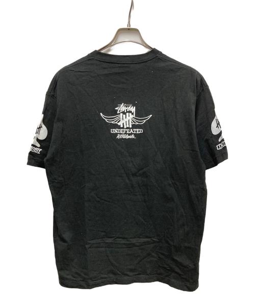 stussy（ステューシー）stussy (ステューシー) UNDEFEATED (アンディフィーテッド) WORDWIDE TEE ブラック サイズ:	SIZE Lの古着・服飾アイテム