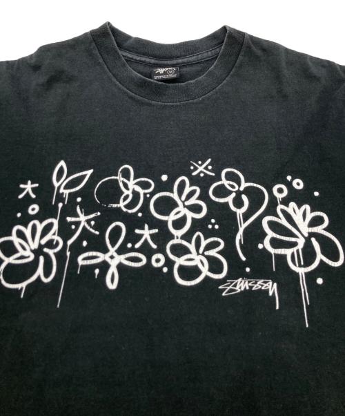 stussy（ステューシー）stussy (ステューシー) フラワーグラフィックTEE ブラック サイズ:Mの古着・服飾アイテム