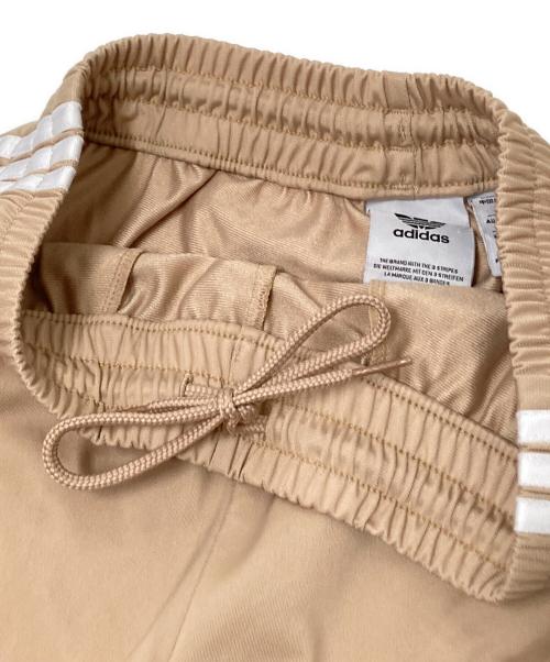adidas（アディダス）adidas (アディダス) アディカラー クラシックス ファイヤーバード トラックパンツ ベージュ サイズ:Sの古着・服飾アイテム