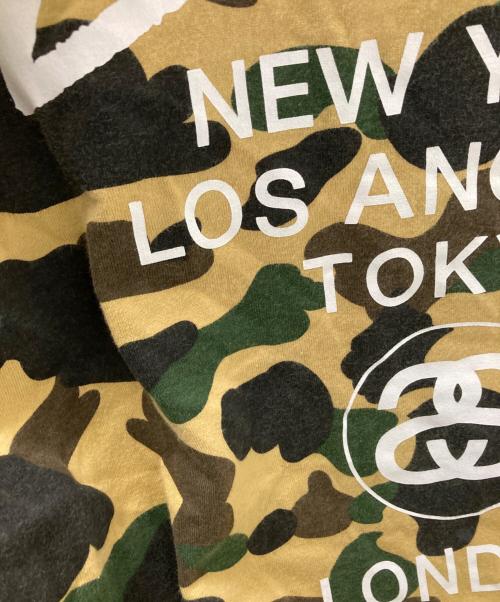 A BATHING APE（アベイシングエイプ）A BATHING APE (アベイシングエイプ) stussy (ステューシー) 30周年記念 1stカモ 猿迷彩 ワールドツアー Tシャツ ベージュ×グリーン サイズ:Mの古着・服飾アイテム
