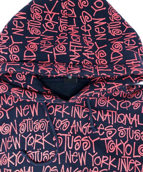 stussy（ステューシー）stussy (ステューシー) ワールドツアー総柄ロゴパーカー レッド×ネイビー サイズ:Ⅿの古着・服飾アイテム