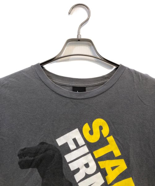 stussy（ステューシー）stussy (ステューシー) 【古着】Stand Firm Dino Tee/スタンドファームダイノTシャツ グレー サイズ:SIZE Mの古着・服飾アイテム