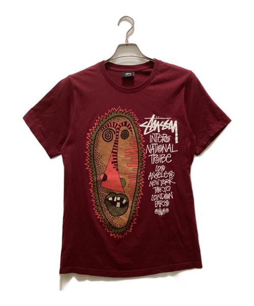 stussy（ステューシー）stussy (ステューシー) トライバルマスクプリントTシャツ パープル サイズ:Sの古着・服飾アイテム