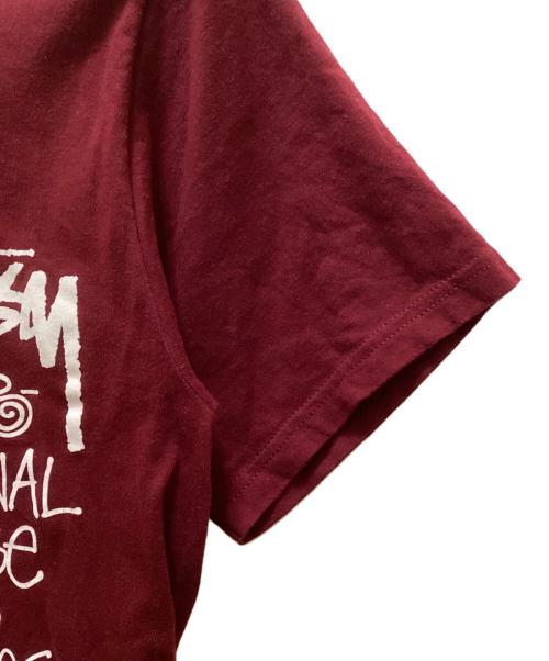 stussy（ステューシー）stussy (ステューシー) トライバルマスクプリントTシャツ パープル サイズ:Sの古着・服飾アイテム