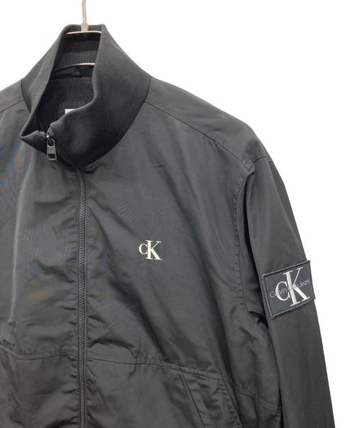 Calvin Klein Jeans（カルバンクラインジーンズ）Calvin Klein Jeans (カルバンクラインジーンズ) ワッペンナイロンジャケット ブラック サイズ:XLの古着・服飾アイテム