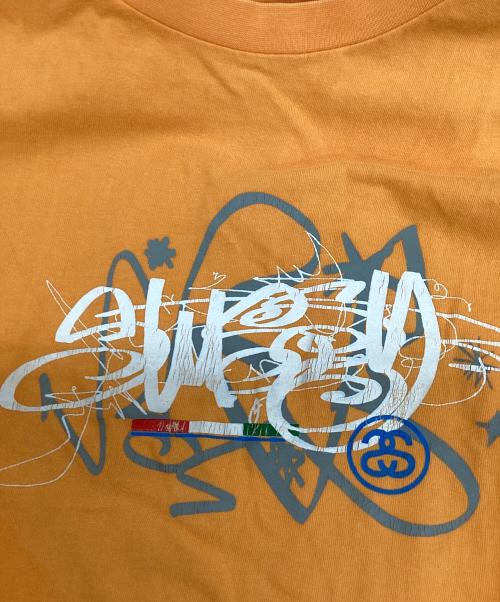 stussy（ステューシー）stussy (ステューシー) プリントTシャツ オレンジ サイズ:Lの古着・服飾アイテム