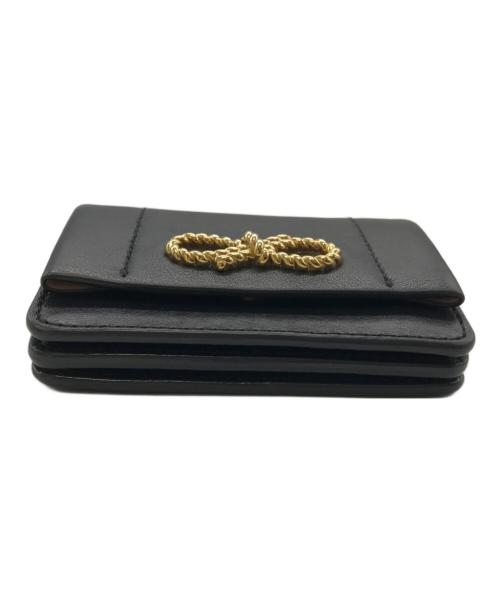 ANYA HINDMARCH（アニヤ・ハインドマーチ）ANYA HINDMARCH (アニヤハインドマーチ) ツイストリボンデザイン 三つ折財布 ブラックの古着・服飾アイテム