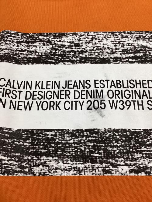 Calvin Klein Jeans（カルバンクラインジーンズ）Calvin Klein Jeans (カルバンクラインジーンズ) プリントスウェット オレンジ サイズ:Lの古着・服飾アイテム