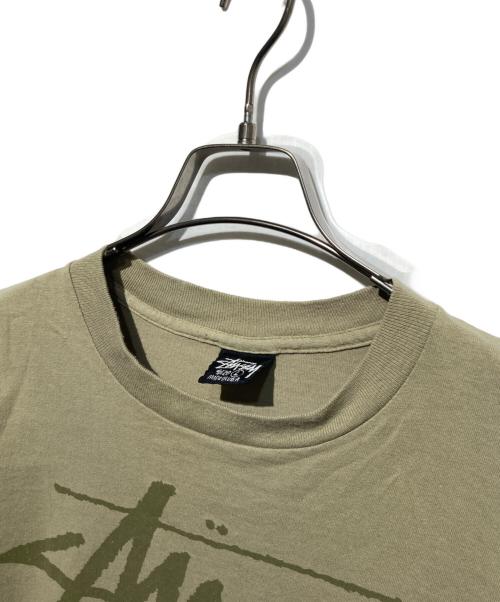 stussy（ステューシー）stussy (ステューシー) BEACH ROOTS プリントTシャツ カーキ サイズ:Lの古着・服飾アイテム