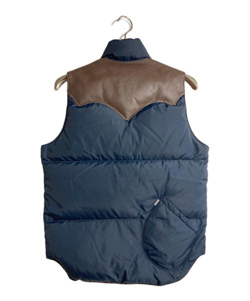 RockyMountainFeatherBed（ロッキーマウンテンフェザーベッド）RockyMountainFeatherBed (ロッキーマウンテンフェザーベッド) CHARI & CO NYC (チャリアンドコーニューヨーク) 別注ロゴ刺繍ダウンベスト ブラウン×ネイビー サイズ:Sの古着・服飾アイテム