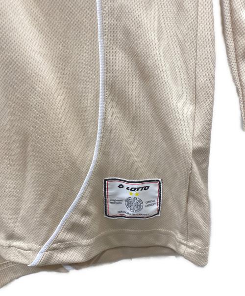 LOTTO（ロット）LOTTO (ロット) Diaspora skateboards (ディアスポラスケートボードズ) Scudetto Shirt ベージュ サイズ:Ｍの古着・服飾アイテム