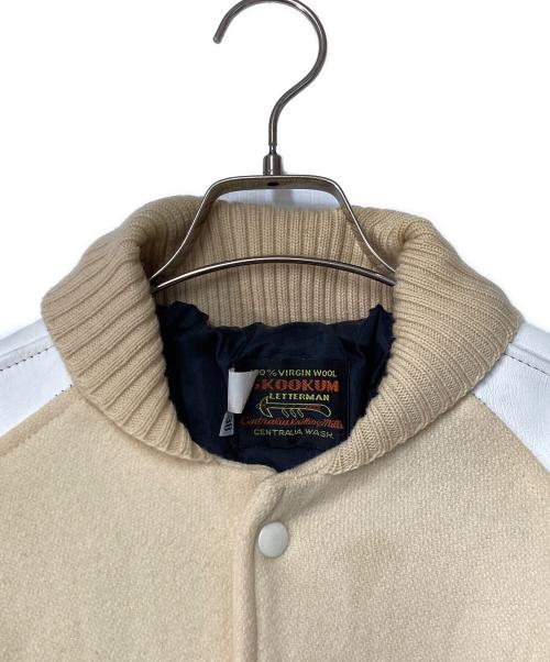 skookum（スクーカム）skookum (スクーカム) レザースリーブスタジャン USA製 ベージュ×ホワイト サイズ:38の古着・服飾アイテム