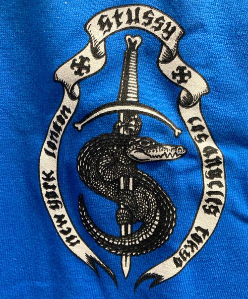 stussy（ステューシー）stussy (ステューシー) GATOR CREST T / ワニ紋章プリントTシャツ ブルー サイズ:XLの古着・服飾アイテム