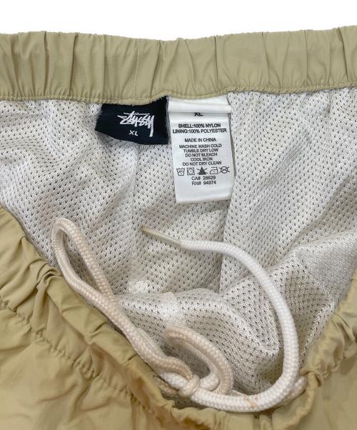 stussy（ステューシー）stussy (ステューシー) Sロゴナイロントラックパンツ ベージュ サイズ:XLの古着・服飾アイテム