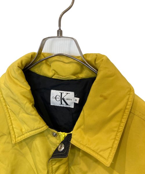 ck Calvin Klein（シーケーカルバンクライン）ck Calvin Klein (シーケーカルバンクライン) ロゴパッチダウンジャケット　CJ 86064 イエロー サイズ:Mの古着・服飾アイテム