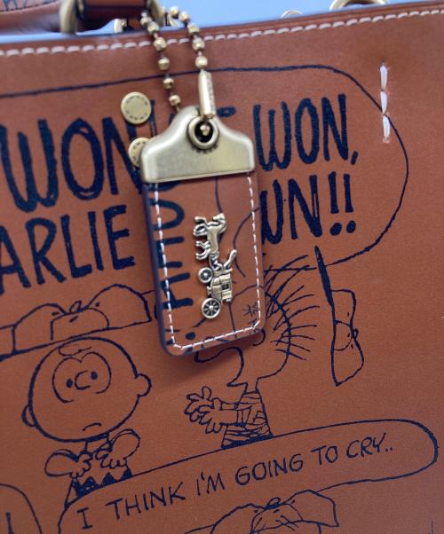 COACH（コーチ）COACH (コーチ) PEANUTS (ピーナッツ) ローグ バッグ・ニュースペーパー プリント/CBF67 ブラウンの古着・服飾アイテム