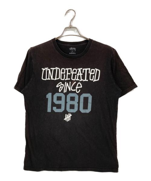 stussy（ステューシー）stussy (ステューシー) UNDEFEATED (アンディフィーテッド) プリントTシャツ ブラック サイズ:Lの古着・服飾アイテム