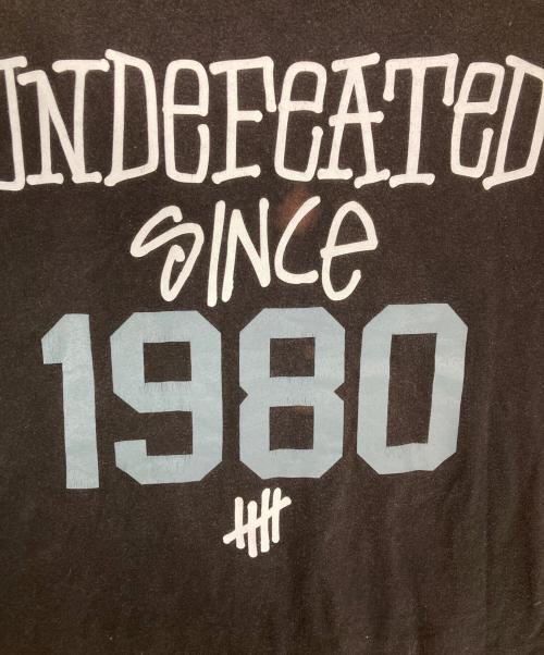 stussy（ステューシー）stussy (ステューシー) UNDEFEATED (アンディフィーテッド) プリントTシャツ ブラック サイズ:Lの古着・服飾アイテム