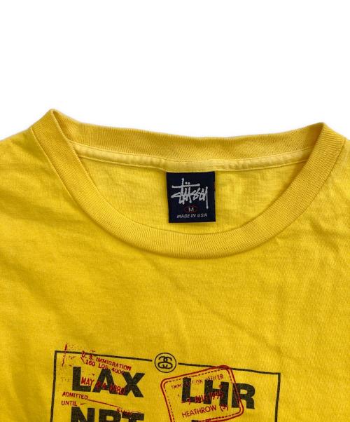 stussy（ステューシー）stussy (ステューシー) AIRPORT CODE TSHIRT/プリントTシャツ イエロー サイズ:Mの古着・服飾アイテム