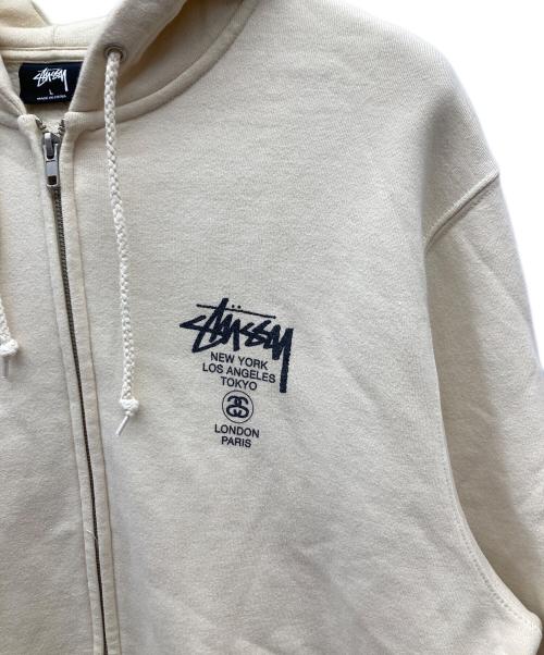 stussy（ステューシー）stussy (ステューシー) WORLD TOUR ZIP HOOD/ワールドツアージップパーカージップパーカー ベージュ サイズ:Lの古着・服飾アイテム