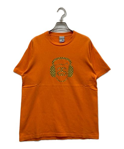 stussy（ステューシー）stussy (ステューシー) モノグラムヘッドフォンTシャツ オレンジ サイズ:Mの古着・服飾アイテム