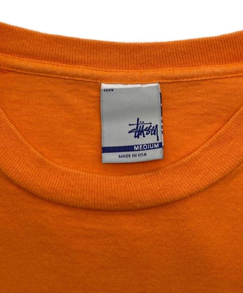 stussy（ステューシー）stussy (ステューシー) モノグラムヘッドフォンTシャツ オレンジ サイズ:Mの古着・服飾アイテム
