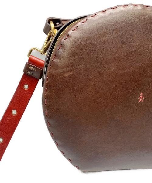 HENRY BEGUELIN（エンリーベグリン）HENRY BEGUELIN (エンリーベグリン) レザーラウンドバッグ　HENRY BEGUELIN レッド×ブラウンの古着・服飾アイテム