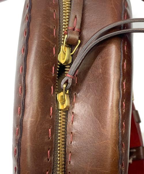 HENRY BEGUELIN（エンリーベグリン）HENRY BEGUELIN (エンリーベグリン) レザーラウンドバッグ　HENRY BEGUELIN レッド×ブラウンの古着・服飾アイテム
