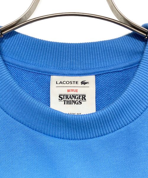 LACOSTE（ラコステ）LACOSTE (ラコステ) NETFLIX (ネットフリックス) アレンジワニロゴクルーネックスウェット スカイブルー サイズ:SIZE 4の古着・服飾アイテム